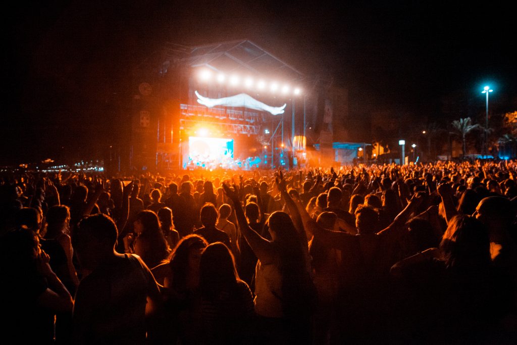 View of a festival stage with people or audience with hands in the air